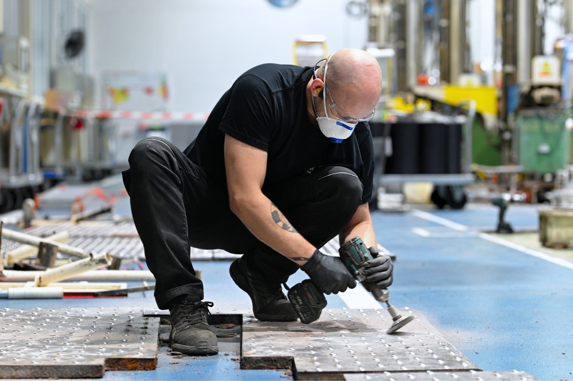 mężczyzna w masce przeciwpyłowej oczyszcający manualnie stanowiskopracy - moulage