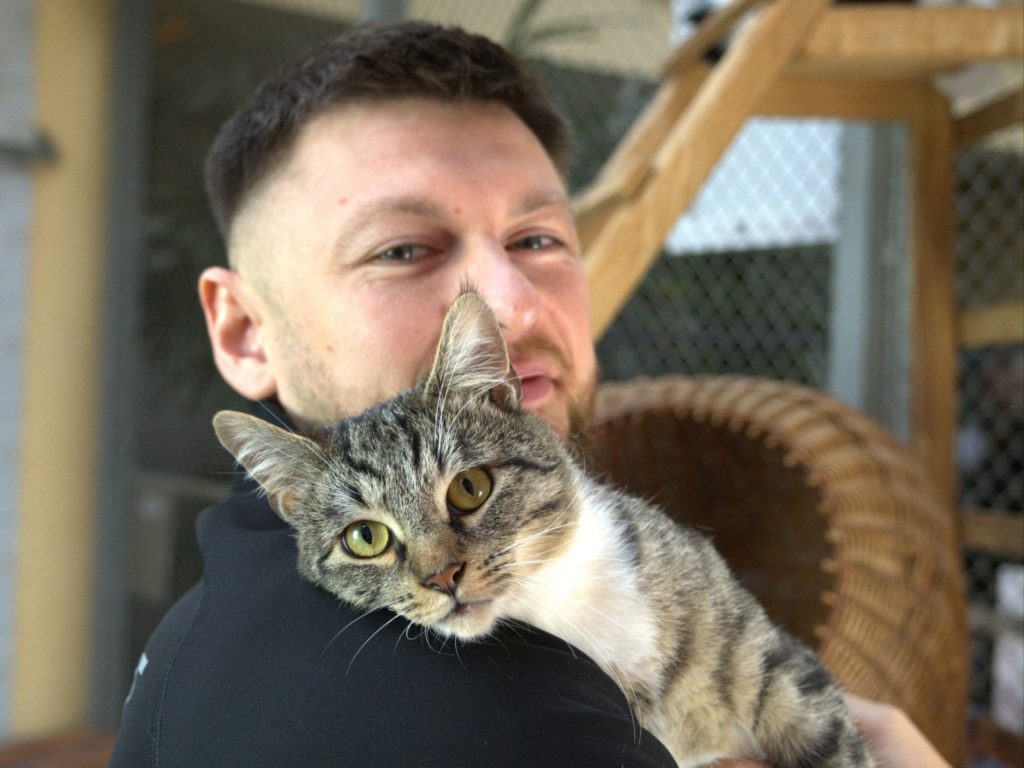 mężczyzna z kotem na ramieniu